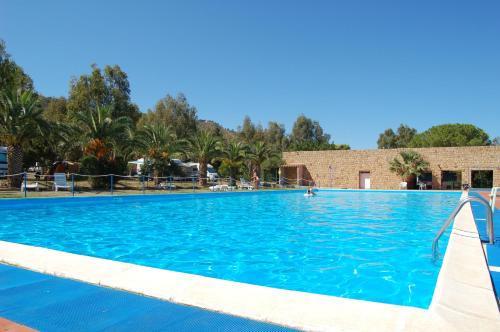 une grande piscine d'eau bleue dans l'établissement Camping Costa Ponente, à Cefalù