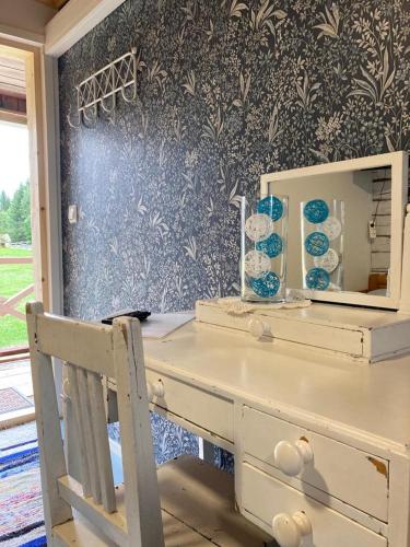 a desk with a mirror and a chair in a room at Valkeisen Loma in Ähtäri