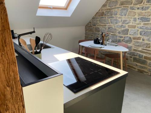 a kitchen with a sink and a table in a room at Fenêtre sur Theux in Theux