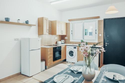 a kitchen with a table with a vase of flowers at Elegant 1 Bedroom Apartment - Great Kings Resort Protaras, Kapparis in Paralimni
