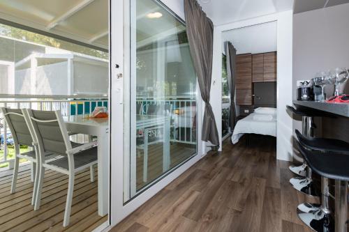 a room with a balcony with a table and chairs at Luxury Camp at Union Lido in Cavallino-Treporti