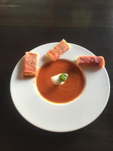 a white plate with a bowl of soup and crackers at Hotel Hippel Krone in Kerzers