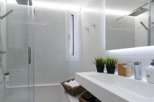 a white bathroom with a sink and a shower at EIFFEL BRIDGE BOUTIQUE APARTMENT in Girona