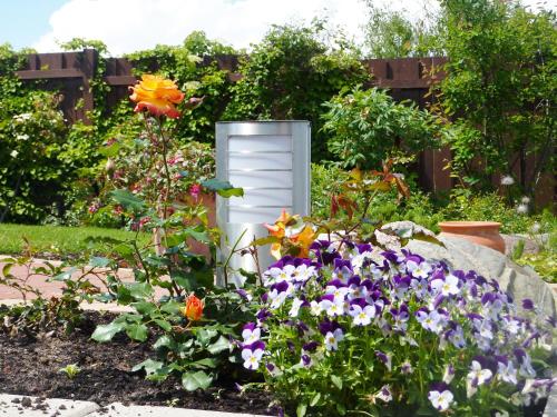 a garden with colorful flowers and a white object at Hotel Inselhof in Malchow