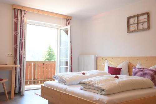 1 dormitorio con 2 camas y ventana grande en Haus Mortna, en Liesing