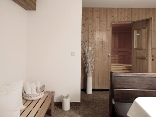 a bedroom with white walls and a table and a bench at Unterwirt - Das kleine Gourmethotel in Ebbs