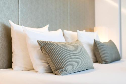 a bunch of pillows sitting on a bed at Holiday Inn Eindhoven Centre by IHG in Eindhoven