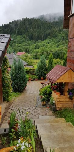 a garden with a stone walkway next to a house at Pensiunea Casa Motilor in Bucium