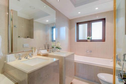 a bathroom with two sinks and a tub and a toilet at Durrani Homes - Souk Al Bahar Luxury Living with Burj & Fountain Views in Dubai