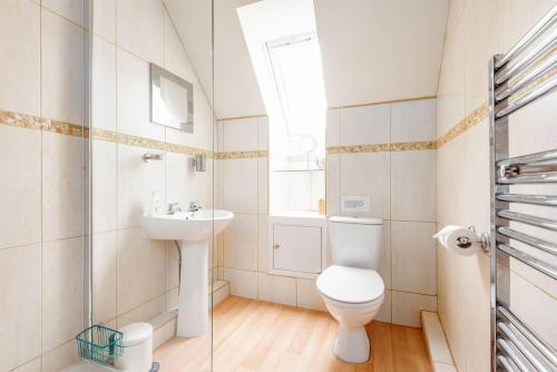 a bathroom with a toilet and a sink and a window at Muir Park Cottage , 5 Mins to St Andrews , Parking in St. Andrews