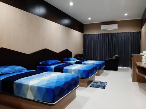 a bedroom with two beds with blue pillows at Tho Mai Resort in Wang Chan