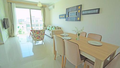 a dining room with a wooden table and chairs at Aqua Royal Alexus Luxury Holiday Apartments Girne in Kérynia