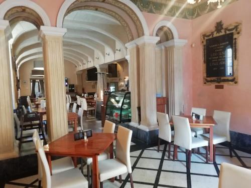 a restaurant with white chairs and tables and columns at MYN in Rabat in Rabat
