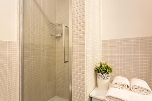 a bathroom with a shower and a toilet with a potted plant at Marlin Rooms in Cagliari