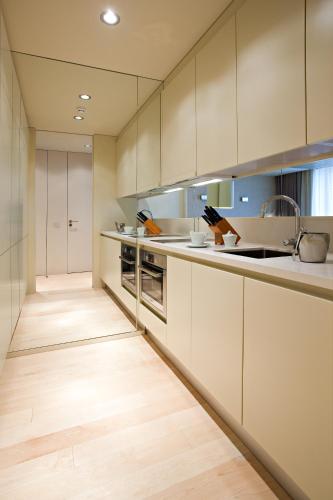 a kitchen with white cabinets and a wooden floor at Serviced Apartments Boavista Palace in Porto