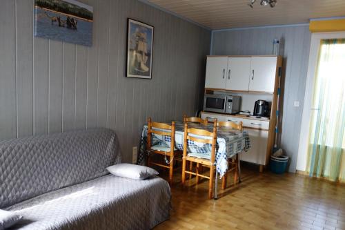 une chambre avec un lit, une table et des chaises dans l'établissement Maison à Narbonne plage proche mer et clape, à Narbonne-Plage