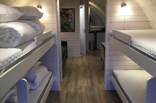 Cette chambre comprend deux étagères remplies de matelas blancs. dans l'établissement Naturhytter, à Kjellerup