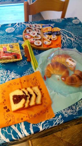 een tafel met een blauwe tafeldoek met gebak en zoete deegwaren bij Hedera Capri B&B in Anacapri
