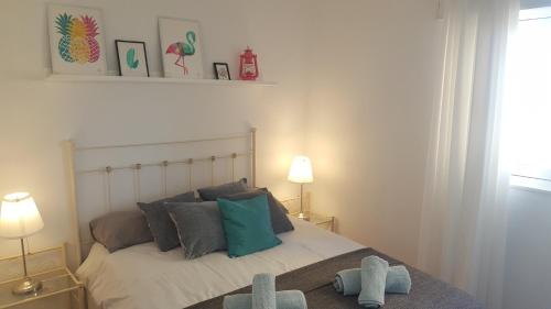 ロケタス・デ・マルにあるEl Palmeralのベッドルーム1室(青とグレーの枕が備わるベッド1台付)