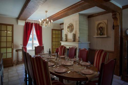 a dining room with a long table and chairs at Demeure du Haut Canteloup in Honfleur