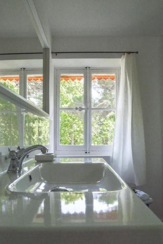 une salle de bain avec une baignoire et une fenêtre dans l'établissement Le Pavillon d'Arnajon, à Le Puy-Sainte-Réparade