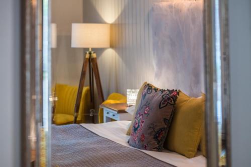 a hotel room with a bed with a mirror at Chester House Hotel in Bourton on the Water