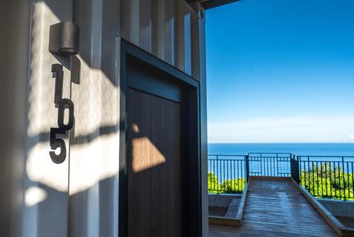 a door to a building with a view of the ocean at 濱境行旅 Begin Inn in Xiaoliuqiu