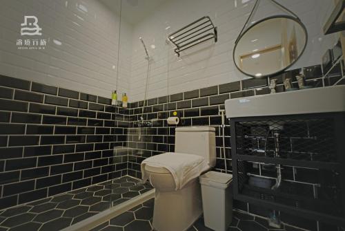 a black and white bathroom with a toilet and a mirror at 濱境行旅 Begin Inn in Xiaoliuqiu