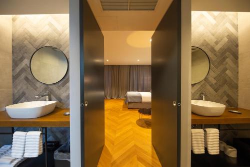 een badkamer met 2 wastafels en een slaapkamer bij Muse luxury rooms in Zadar