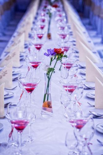 a long table with wine glasses and flowers on it at Hotel Europa in Liptovský Mikuláš