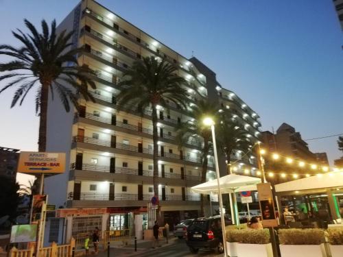 un edificio alto con palme di fronte di BERMUDAS-TURIS Apartamentos a Benidorm