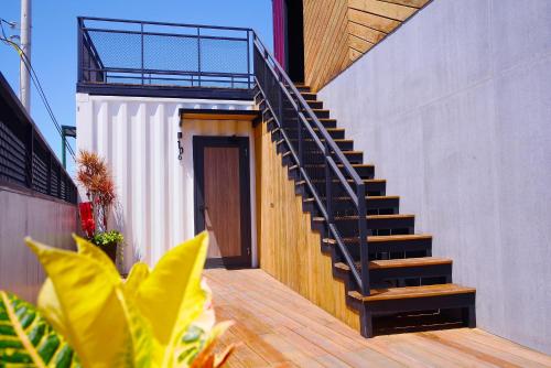 a staircase leading up to a house with wooden floors at 濱境行旅 Begin Inn in Xiaoliuqiu