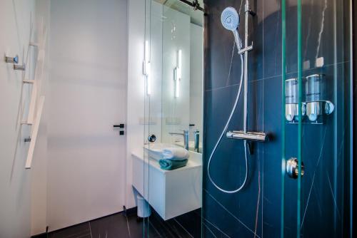 baño con ducha y puerta de cristal en Apartament WIDOK en Olsztyn