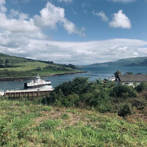 a boat is docked at a dock on a river at White Watch in Lochaline