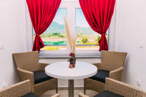 a room with a table and chairs and a window at Apartmani Markešić Ramsko jezero in Prozor