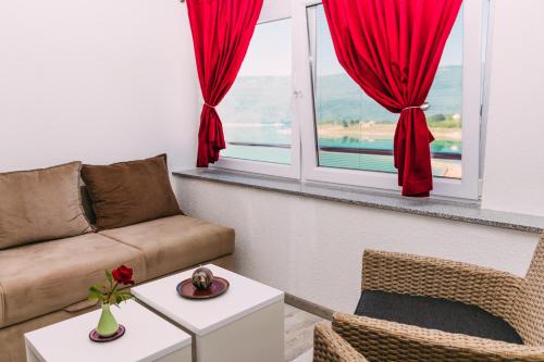 a living room with a couch and a window at Apartmani Markešić Ramsko jezero in Prozor