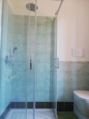 a bathroom with a glass shower with a toilet at La Cuppulata in Budoni
