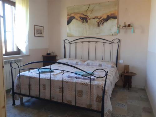 Bett in einem Schlafzimmer mit Wandgemälde in der Unterkunft Agriturismo Enjoy Sunset in Cinigiano