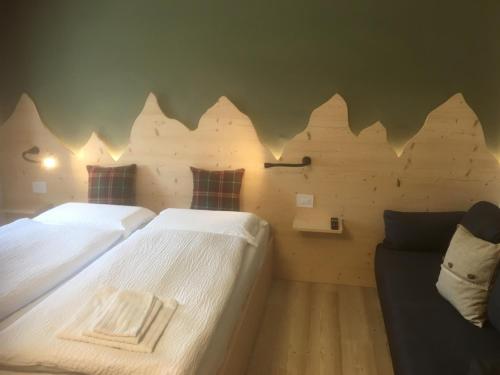 a bedroom with two beds and a couch at B and B nonna Rosa vista Lagorai in Capriana