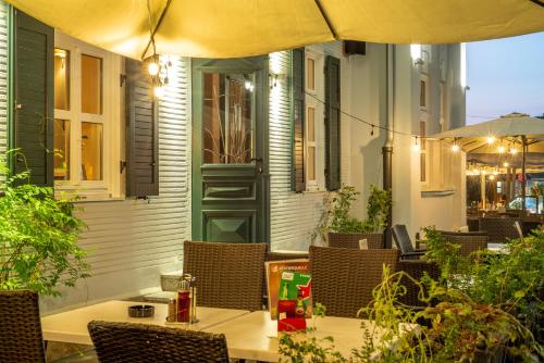 an outdoor patio with a table and chairs with an umbrella at Vila Emilia in Vrnjačka Banja