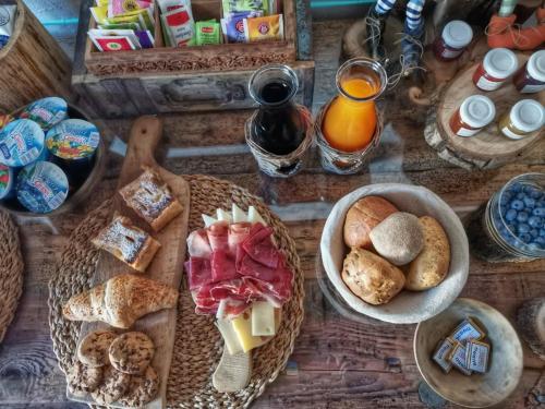 B&B Le Ciaf في تيمو: طاولة خشبية مليئة بأطباق الطعام والخبز