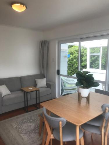 a living room with a table and a couch at ROTORUA EASTSIDE APARTMENTS in Rotorua