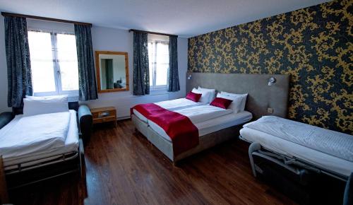 una camera d'albergo con due letti e uno specchio di Hotel Sonne Interlaken-Matten a Interlaken