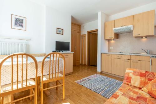 eine Küche und ein Wohnzimmer mit einem Tisch und Stühlen in der Unterkunft Garni Dürrenstein in Schenna