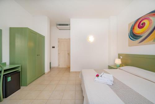 a bedroom with a bed and a green cabinet at Hotel Marinaro in Santa Teresa Gallura