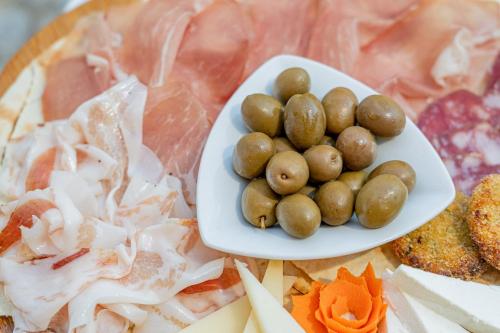 a plate of food with meat and vegetables on a table at Hotel Marinaro in Santa Teresa Gallura