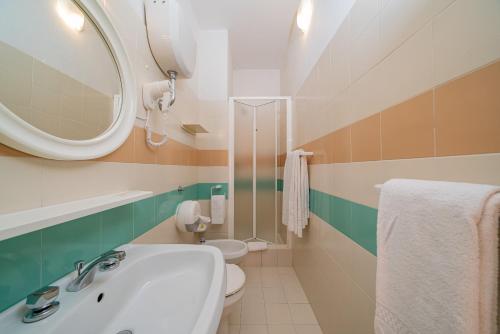 a bathroom with a sink and a mirror and a toilet at Hotel Marinaro in Santa Teresa Gallura