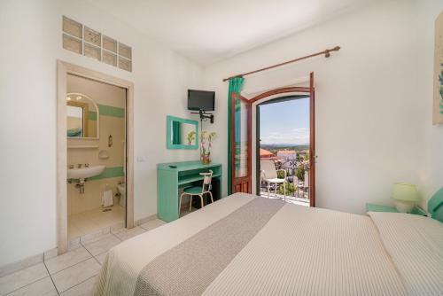 a bedroom with a bed and a bathroom with a sink at Hotel Marinaro in Santa Teresa Gallura