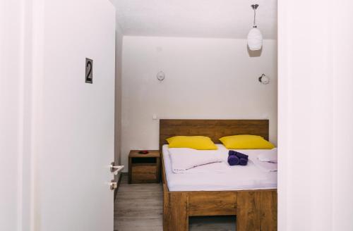 a bedroom with a bed with yellow pillows at Apartmani Markešić Ramsko jezero in Prozor