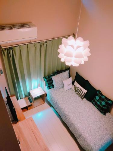 a living room with a couch and a chandelier at MEME Inn与野本町駅前 in Saitama